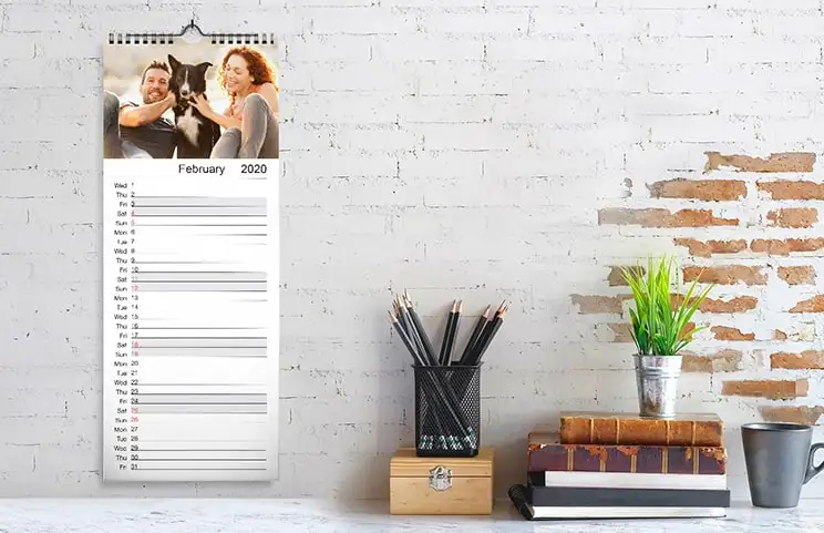 Woman looking at customised calendar with photo of dog taken on mobile